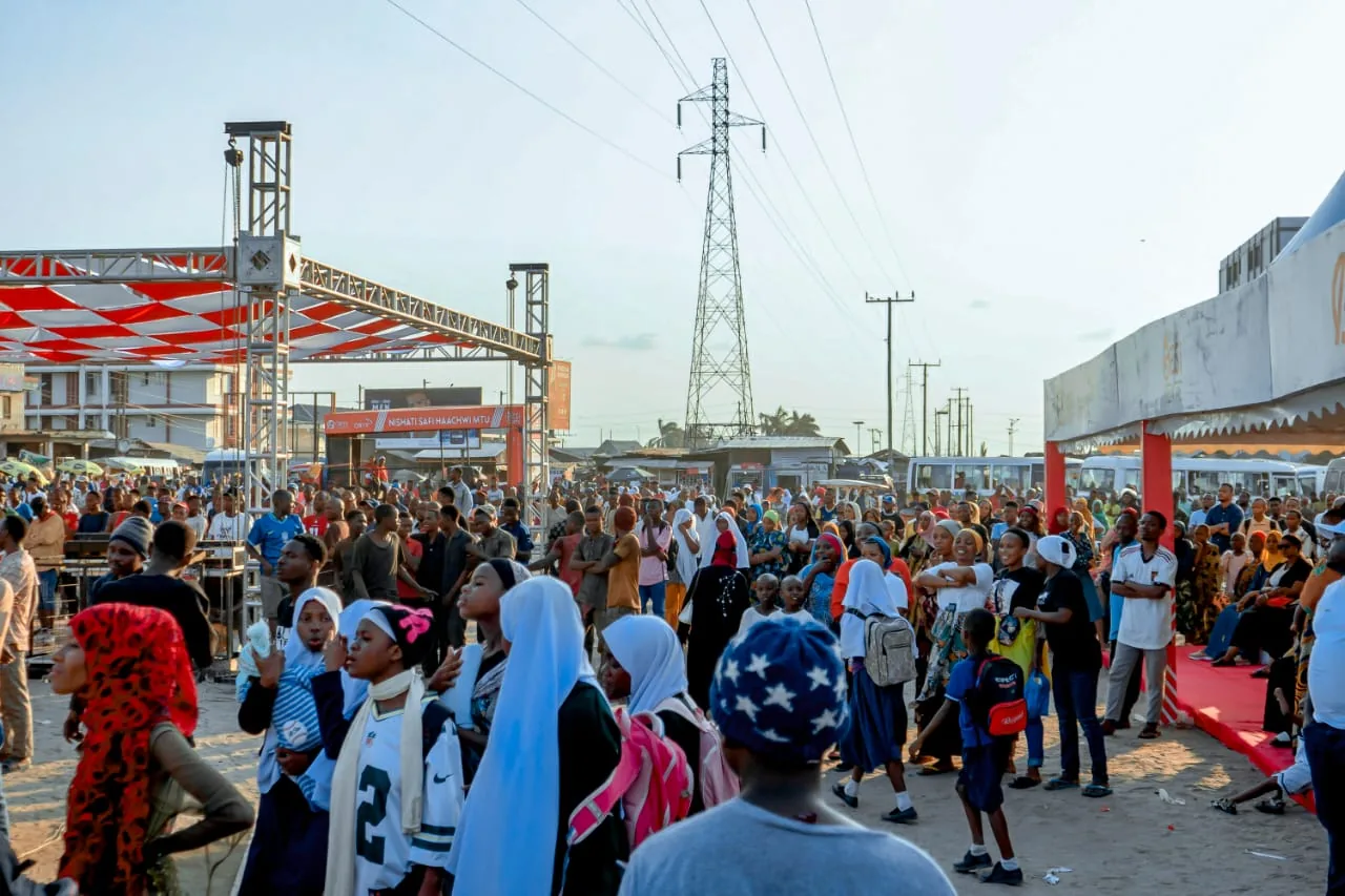 Outdoor event crowd near a production structure
