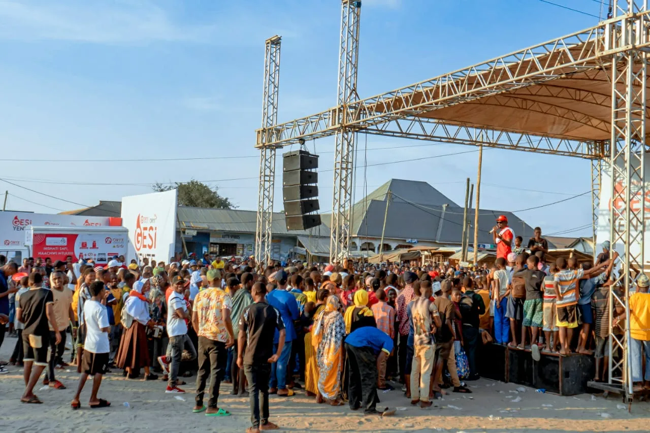 Visitors gathered near an outdoor event stage and production structure